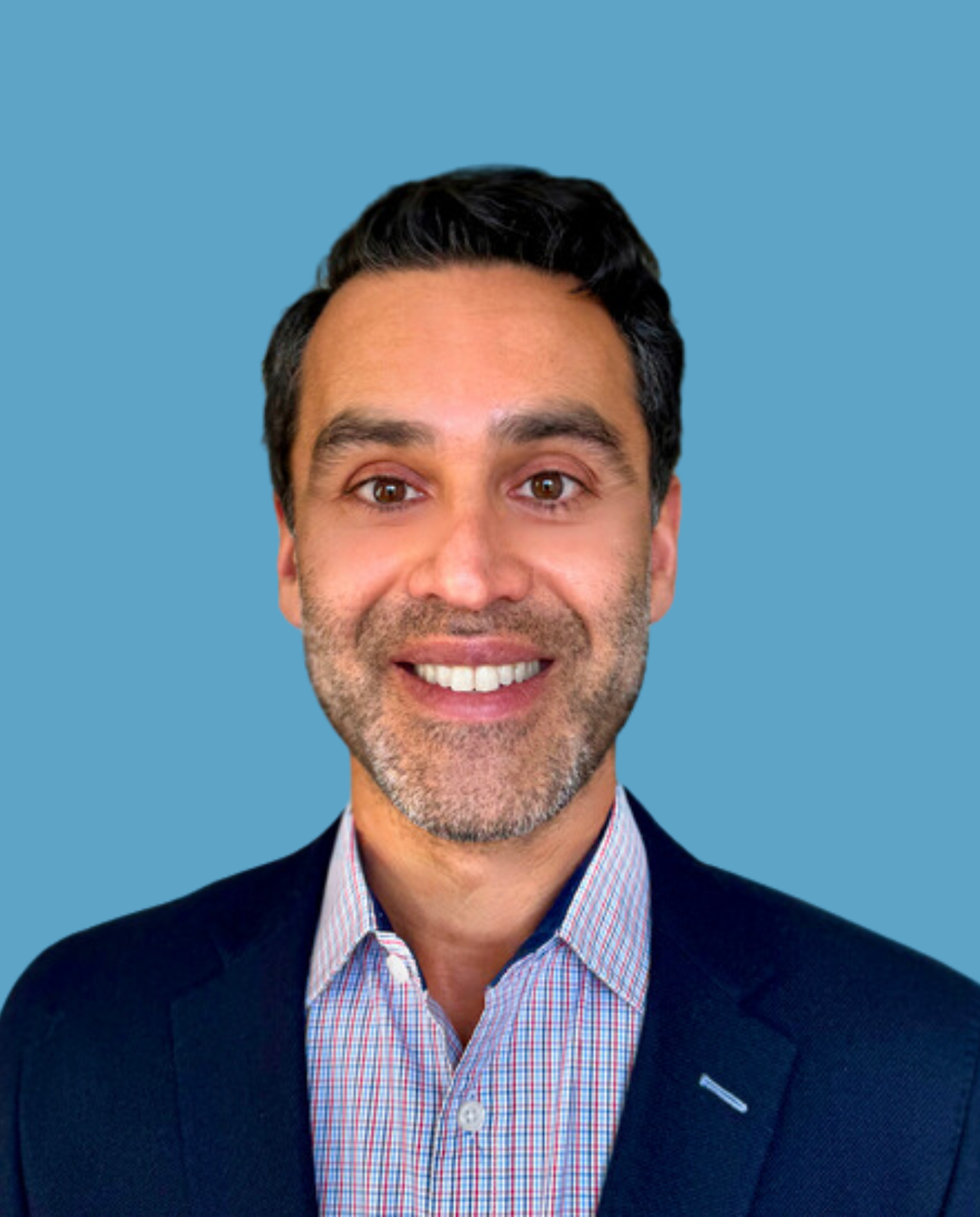 headshot of a man wearing a plaid button up shirt and blazer